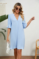 Woman wearing light blue Dainty Charm Casual Ruffle Dress with ruffled V-neck and 3/4 sleeves holding white handbag