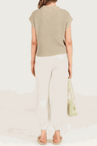 Woman wearing beige Comfy Couture Knit Sweater and white high-waisted pants two-piece set back view