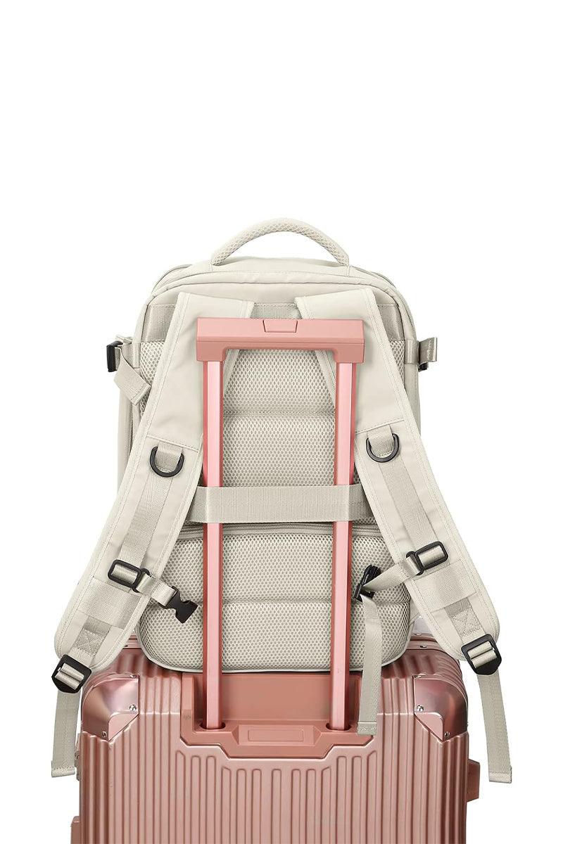 Chic Wanderlust Waterproof Backpack shown attached to a pink rolling suitcase handle, highlighting ergonomic back and adjustable straps.