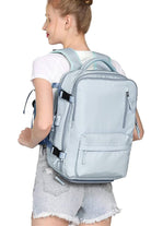 Chic Wanderlust Waterproof Backpack in light blue worn by woman, featuring multiple compartments and ergonomic straps