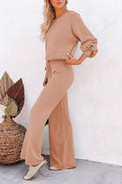 Woman wearing round neck loose fit cozy two-piece set in beige with wide-leg pants and long sleeves