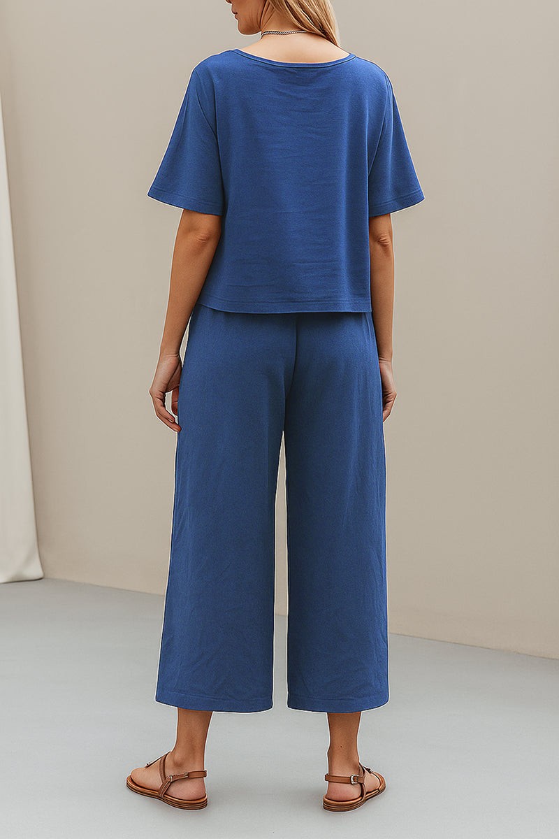 Woman wearing blue loose fit co-ord set with short sleeves and wide-leg pants standing indoors