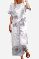 Woman wearing white floral loose fit co-ord set with wide-leg trousers and relaxed short-sleeve top
