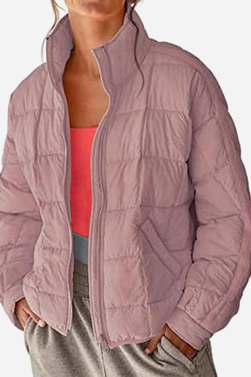 Lightweight puffer travel jacket in mauve color worn with casual outfit, warm and packable design