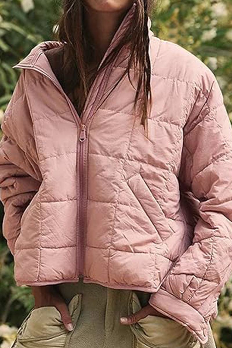 Lightweight pink puffer travel jacket with front zipper and pockets, perfect for versatile and comfortable outdoor wear