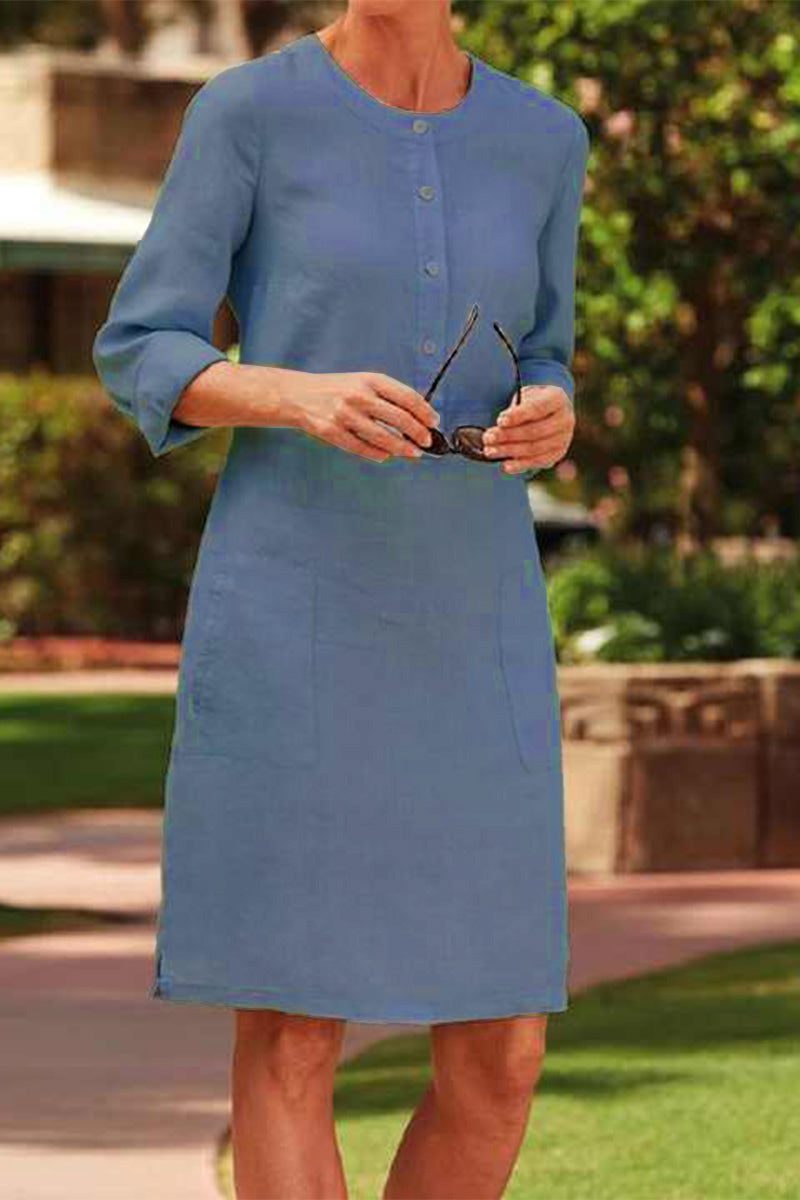 Blue cotton dress with 3/4 rolled sleeves, button front, and pockets in a casual knee-length style