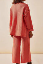 Back view of a woman wearing a coral textured two-piece oversized set with relaxed fit pants and long sleeves, designed for multi-weather comfort.