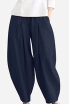 Solid color wide leg cotton pleated pants in navy blue with a voluminous fit and comfortable breathable fabric
