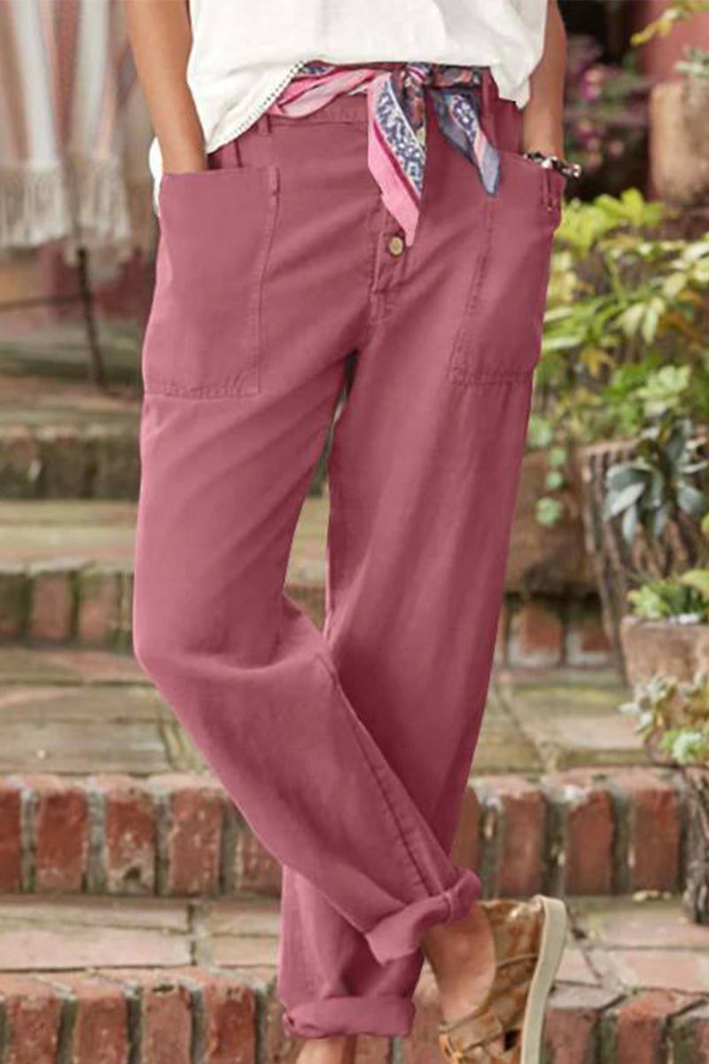 Woman wearing pink casual button-down utility-chic trousers with pockets and rolled cuffs