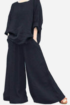 Black wide leg pants with pockets paired with loose black top, bohemian style outfit