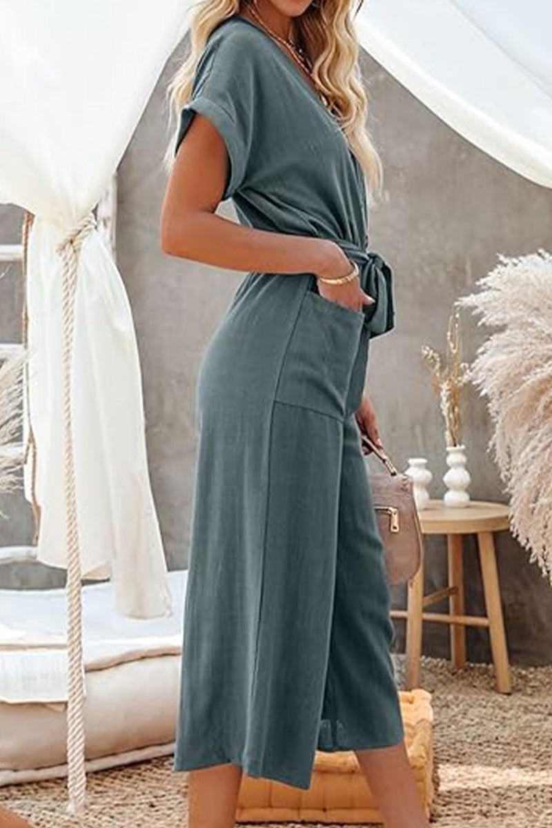 V-neck lace-up pocket jumpsuit with tie in lightweight breathable fabric, featuring wide legs and cap sleeves.