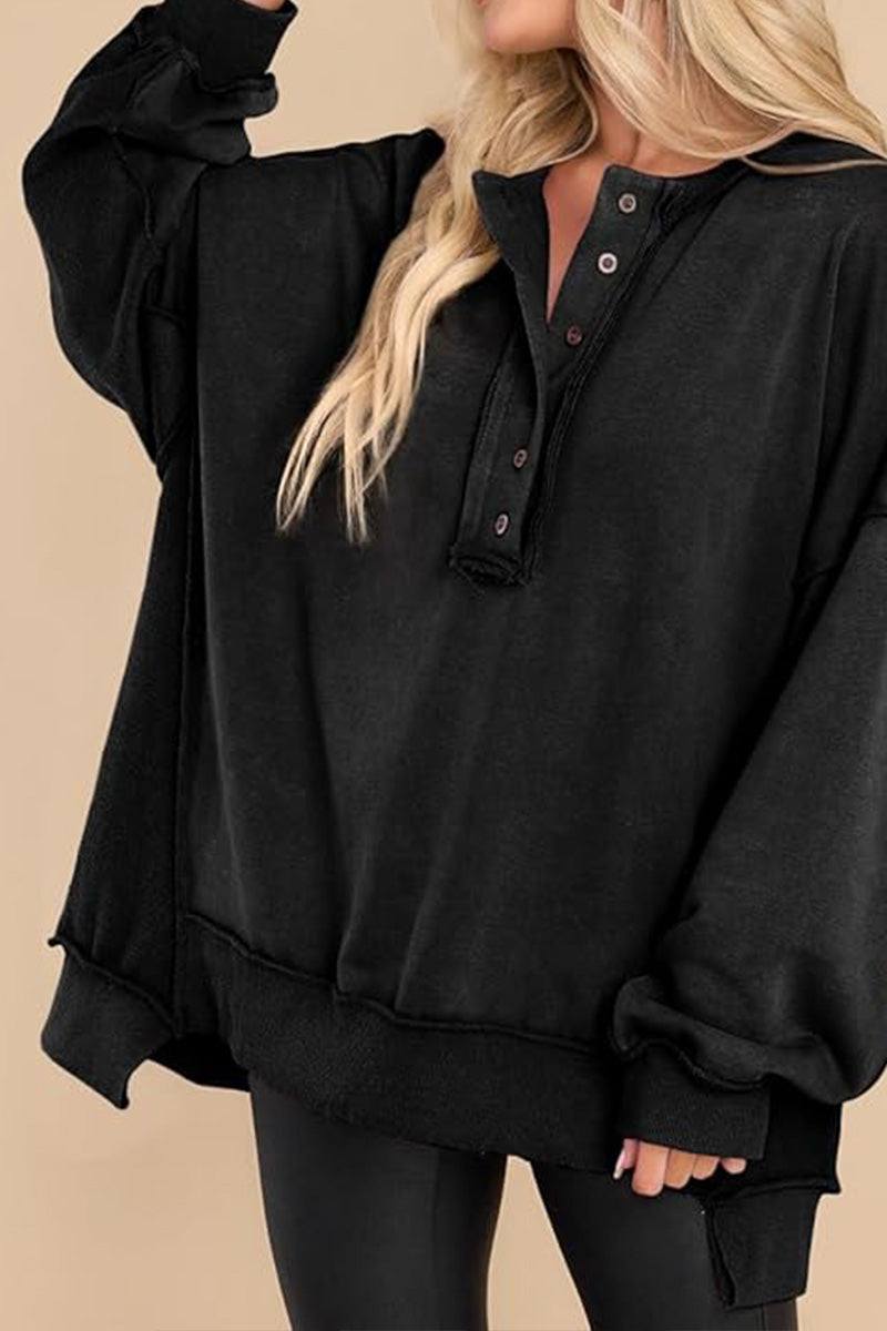 Black oversized urban sweatshirt with buttoned Henley neckline and slouchy sleeves worn by blonde woman