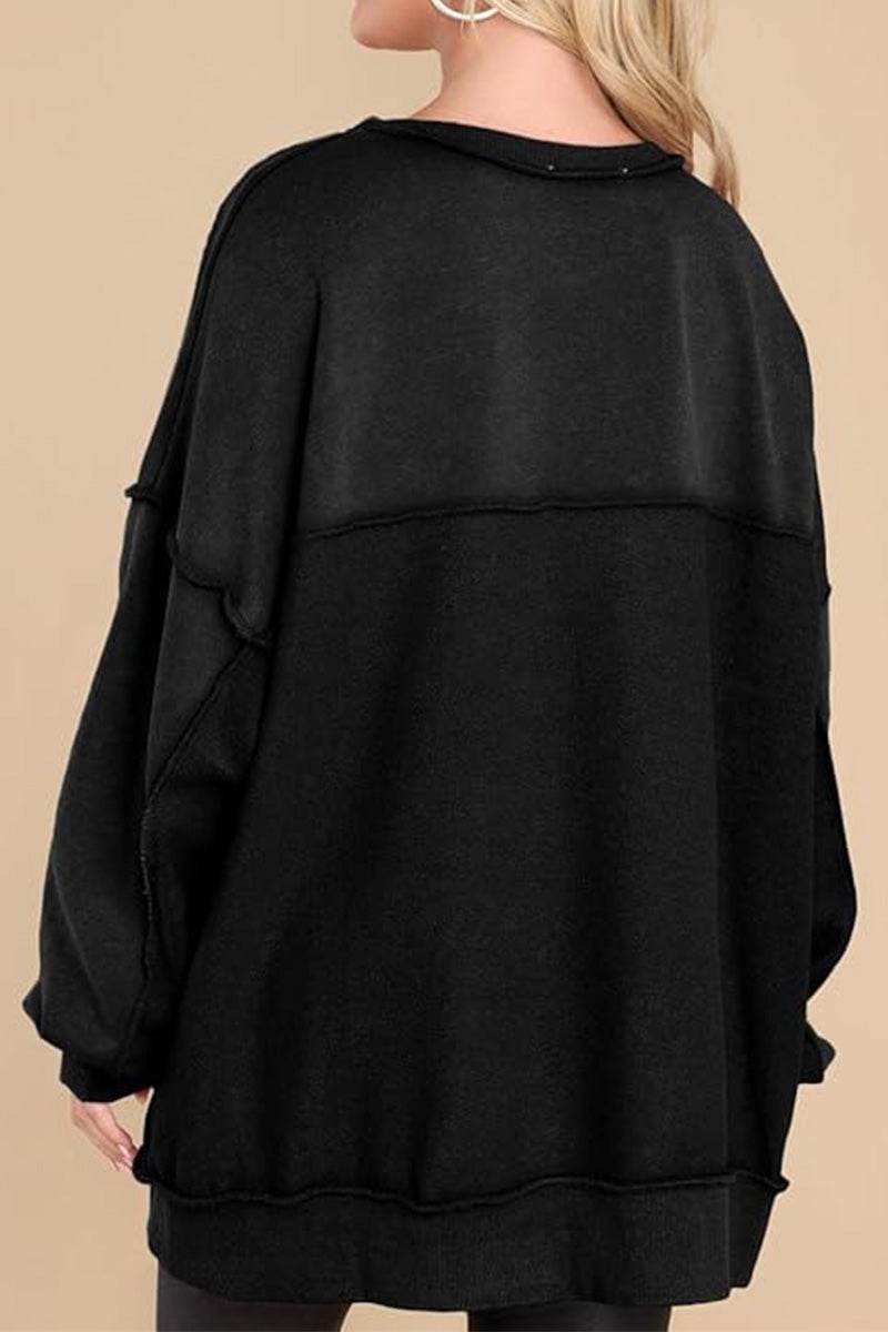 Back view of a black oversized urban sweatshirt with slouchy sleeves and raw seam details on a female model