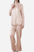 Woman wearing classic beige Mulberry silk sleepwear set with long sleeves and pants
