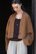 woman wearing brown ramie linen and cotton cardigan with side pocket over black top and beige pants