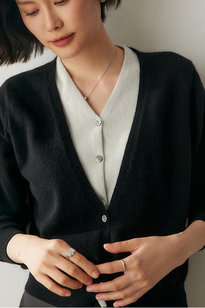 Woman wearing a black and white single-breasted cashmere wool cardigan with relaxed fit and button closure