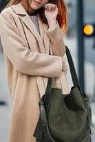 woman carrying vintage charm bag in suede with dual-length straps and spacious design