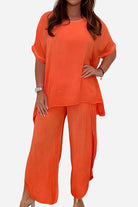 Relaxed linen-like travel 2-piece set in bright orange with loose-fitting top and wide-leg pants for comfortable, wrinkle-resistant style.