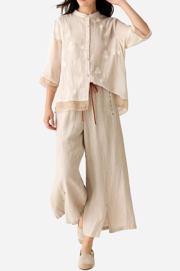 Woman wearing cotton linen Tuscany two-piece set with embroidered sheer top and wide-leg pants