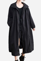 Black oversized all-weather water-resistant windbreaker with hood and drawstrings, styled for comfort and breathability in any weather