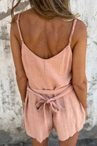 woman wearing pink 100% pure linen breathable natural comfort jumpsuit from the back with adjustable waist tie and thin straps