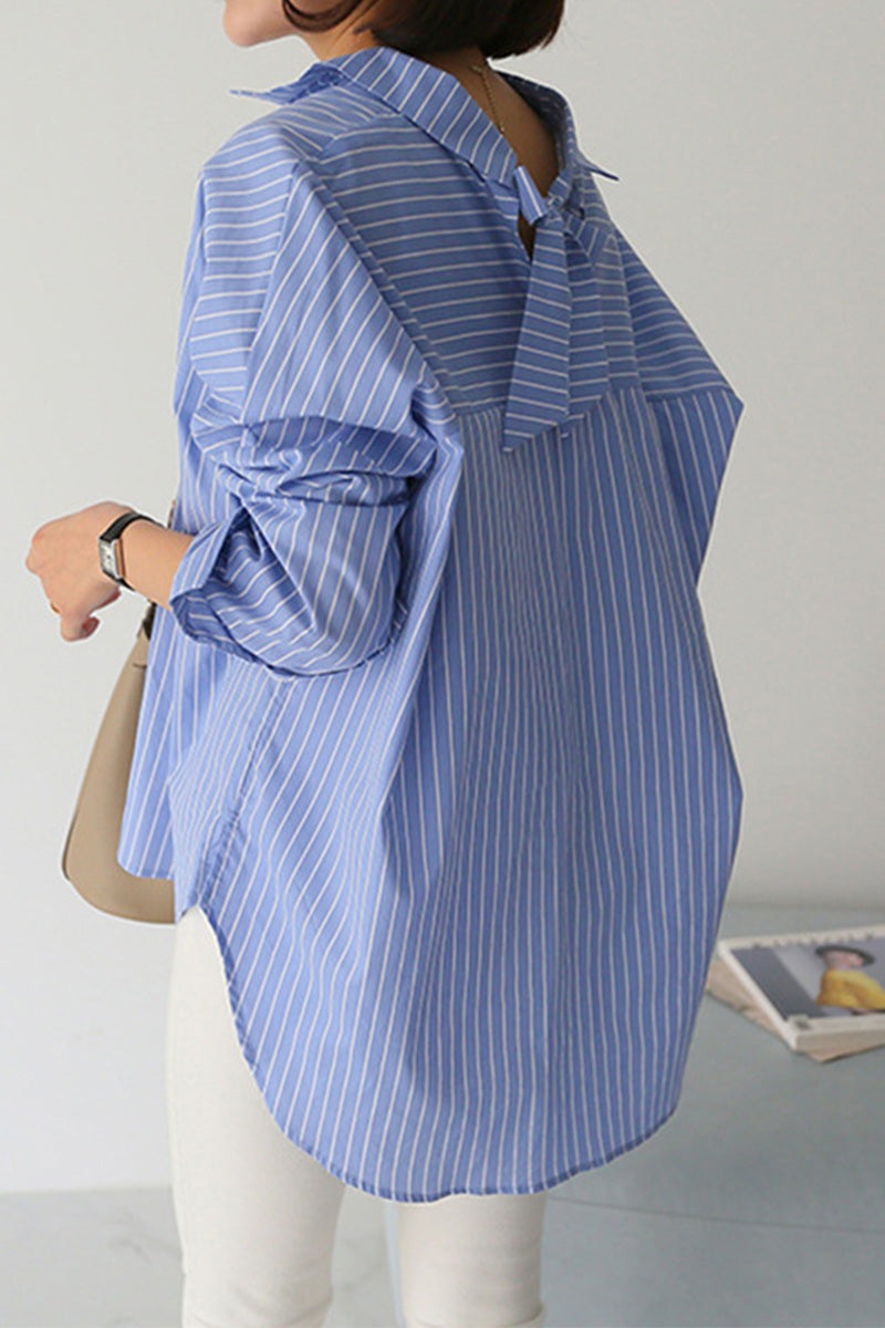 100% cotton oversized blue striped shirt with relaxed fit and long sleeves worn by woman