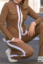 Woman wearing sleek contrast zip two-piece brown outfit with white trim and gold zipper details