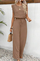 Elegant two-piece set in soft brown fabric with lace details, featuring a sleeveless top and wide-leg pants.