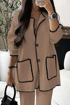 Women's beige contrast-trim knit cardigan with button front and pockets, styled with matching pants.