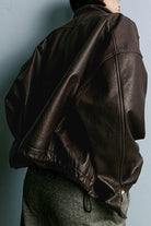 Back view of black genuine sheepskin leather jacket with soft, glossy texture and relaxed fit.
