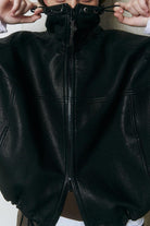 Close-up of black genuine sheepskin leather jacket with high collar and zipper detail