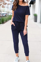 Moonlit Rome Off-Shoulder navy jumpsuit with oblique shoulder design and pockets, casual chic style