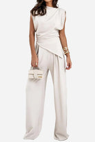 Woman wearing Manhattan Lines Draped sleeveless asymmetrical draped two-piece set with wide-leg palazzo pants in light beige color