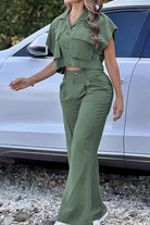 Woman wearing green safari escape two-piece set with big functional pockets and wide-leg pants outdoors near white car