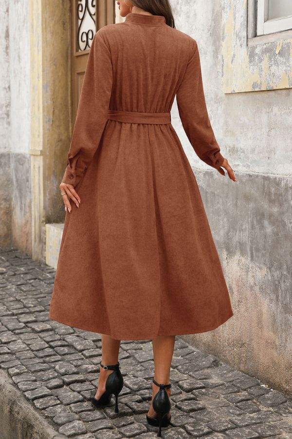 Back view of effortlessly polished corduroy tie-waist dress in rich brown mid-calf length with long sleeves and button cuffs.