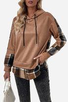 Brown countryside layered hoodie with plaid accents on hem, cuffs, and sleeves worn by a model