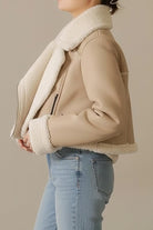 Cropped faux leather sherpa jacket with cream sherpa trim and full lining, styled on model with jeans.