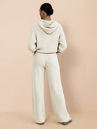 back view of woman wearing cream waffle-knit two-piece hoodie and wide-leg pants set