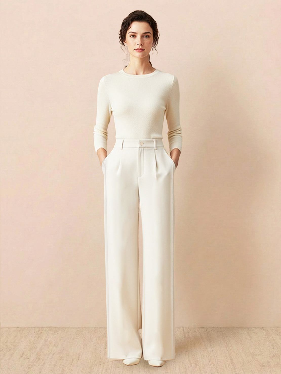 Woman wearing cream wide-leg thermal wool blend trousers with high waist and structured pleats against a beige background