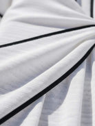 Woman wearing a knot-waist maxi dress with V-neckline, batwing sleeves, and flowing skirt with pockets