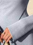 Slim fit asymmetric wrap ribbed knit top with diagonal button closure and flared cuffs