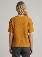 Floral jacquard pleated top with flutter sleeves and 3D floral texture in relaxed A-line silhouette