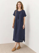100% linen relaxed midi dress with short sleeves, patch pockets, and side slits for comfort and easy movement
