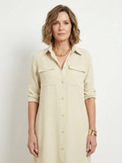 Woman wearing a wrinkle-free maxi button-down dress with side slits, point collar, chest pockets, and rolled-up sleeves