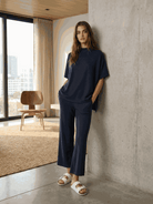 Woman wearing cotton-blend capelet top with batwing sleeves and wide-leg pants in a lounge set