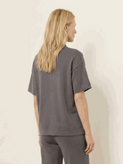 Woman wearing cotton-blend capelet top with batwing sleeves and wide-leg cropped pants lounge set in soft fabric