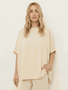 Woman wearing cotton-blend capelet top with batwing sleeves and wide-leg pants lounge set