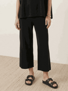 Woman wearing a cotton-blend capelet top with batwing sleeves and wide-leg pants lounge set in neutral tones