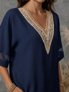 Mature woman wearing a lightweight linen top with V-neck and button detail in light khaki
