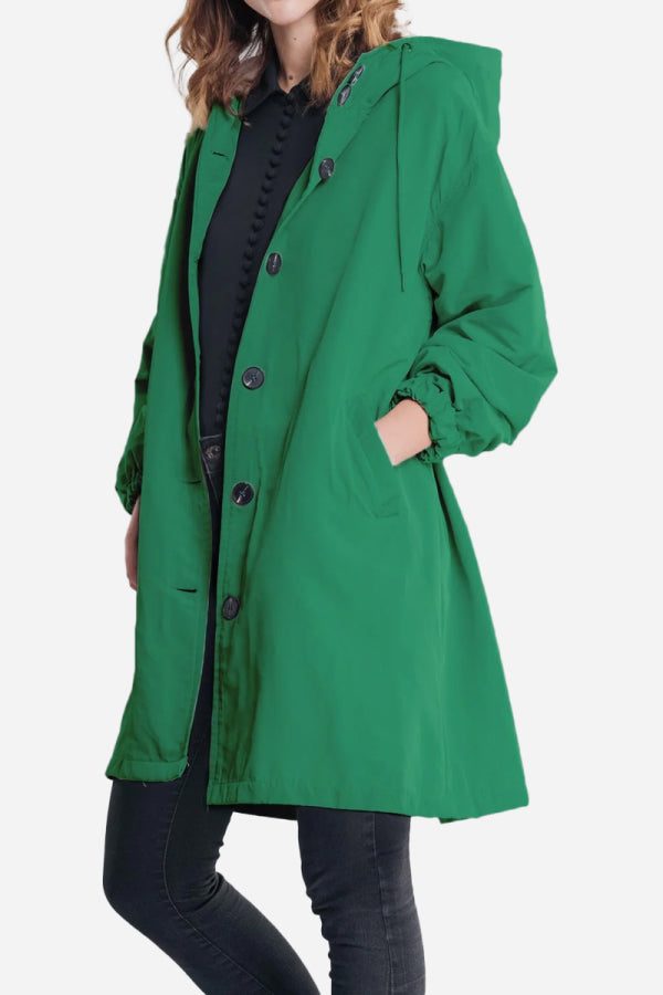 Green oversized water-resistant windbreaker jacket with hood and buttons, styled for casual outdoor wear